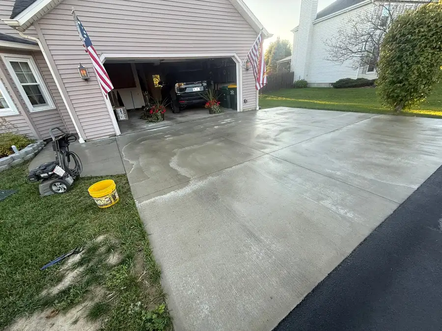 New broom finish concrete driveway apron in front of a two car garage
