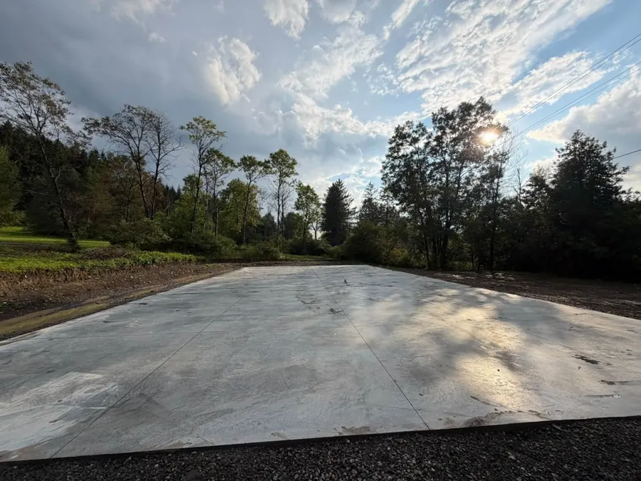 Finished 40 by 80 foot monolithic concrete slab at sunset in North Norwich, NY